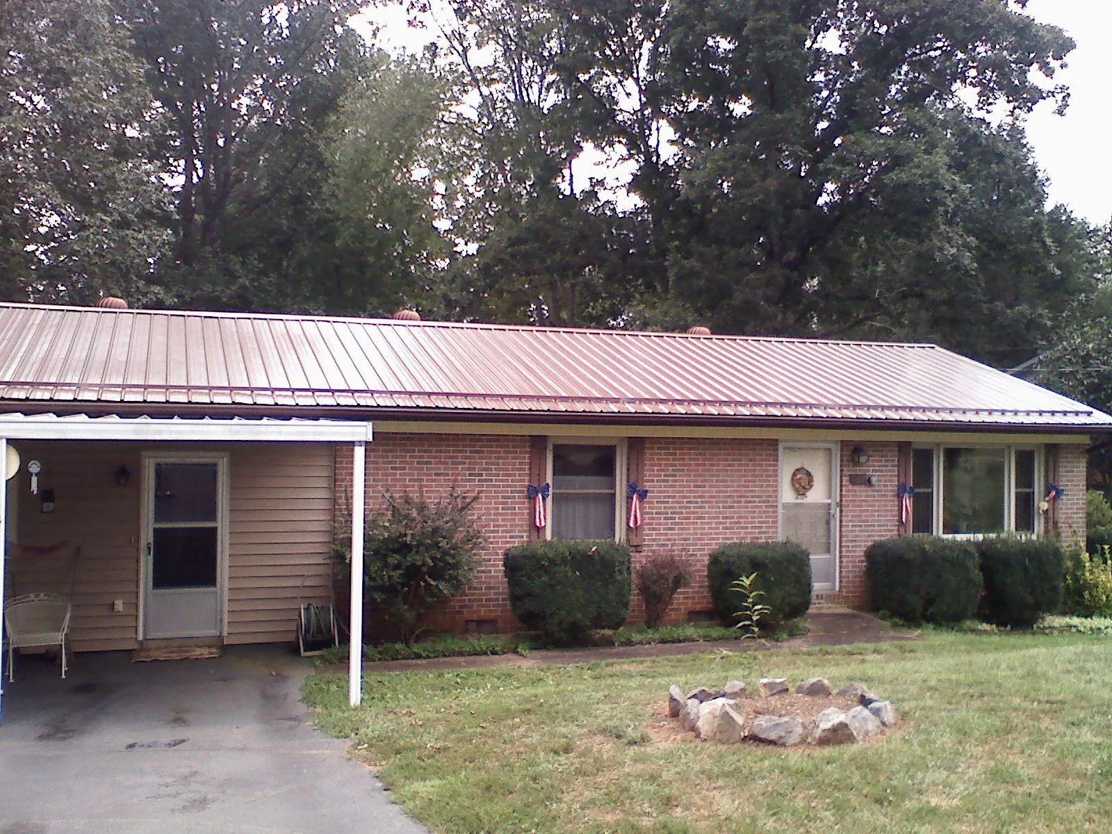Bronze metal roof and carport on a brick ranch home — Roof Repair work by our crew in Pine